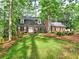 Charming two-story brick home with a lush green lawn and mature trees, offering a serene and inviting curb appeal at 1257 Independence Way, Marietta, GA 30062