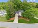 An aerial view showcases this charming home with mature trees and a well-maintained lawn at 1405 Arden Trace Ln, Lawrenceville, GA 30043