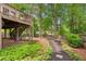 Backyard features a deck, patio, stepping stone pathway, and wood fence border at 1405 Arden Trace Ln, Lawrenceville, GA 30043