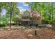 Secluded backyard featuring a cozy firepit area and a screened-in porch with a staircase leading to the yard at 1405 Arden Trace Ln, Lawrenceville, GA 30043