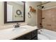 Bathroom with a large dark framed mirror, granite countertop, and tub shower combination at 1405 Arden Trace Ln, Lawrenceville, GA 30043