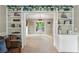 Bright living room featuring built-in shelving that transitions to a sunlit room with access to the outside at 1405 Arden Trace Ln, Lawrenceville, GA 30043