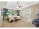 Spacious main bedroom with tray ceiling, ceiling fan, bench, and ensuite bathroom entrance at 1405 Arden Trace Ln, Lawrenceville, GA 30043