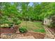 Landscaped backyard with mature trees and bird bath, offering a private outdoor retreat at 3850 Pilgrim Mill Rd, Cumming, GA 30041