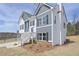 Angled view of a charming two-story home with gray and white siding and well-maintained landscaping at 500 Charleston Pl, Villa Rica, GA 30180