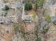 An overhead shot reveals a house with surrounding trees, landscaping, and a cozy fire pit area at 650 Hunterhill Ct, Roswell, GA 30075