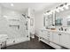 Modern bathroom featuring a marble shower, double vanity with dark fixtures, and a sleek design at 650 Hunterhill Ct, Roswell, GA 30075