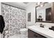 Charming bathroom featuring a floral shower curtain, patterned floors, and an ornate framed mirror above the vanity at 650 Hunterhill Ct, Roswell, GA 30075