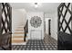Bright foyer with decorative tile flooring, a staircase, and an elegant lighting fixture creating a welcoming entrance at 650 Hunterhill Ct, Roswell, GA 30075