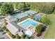 Aerial view of neighborhood amenities including a large pool, tennis courts, and a clubhouse surrounded by lush greenery at 3376 Hickory Ln, Powder Springs, GA 30127