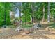 Charming backyard patio with stone ground cover, Adirondack chairs and a fire pit provides a relaxing retreat at 3376 Hickory Ln, Powder Springs, GA 30127
