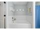 Bright bathroom featuring a white bathtub with white tile surround and modern fixtures at 3376 Hickory Ln, Powder Springs, GA 30127