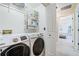 Bright laundry room with washer, dryer and shelving with doorway to bedroom at 3376 Hickory Ln, Powder Springs, GA 30127