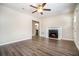 Open-concept living room featuring dark wood floors, a ceiling fan, and a classic fireplace at 4004 Knightsbridge Nw Rd, Kennesaw, GA 30144