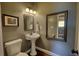 Cozy half bathroom featuring a pedestal sink, framed mirror, and neutral wall color at 547 Ellington Rd, Oxford, GA 30054
