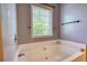 Close-up of a white soaking tub under a window with natural light at 547 Ellington Rd, Oxford, GA 30054