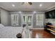 Bedroom featuring hardwood floors, natural light, a TV, and a four-poster bed at 547 Ellington Rd, Oxford, GA 30054