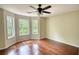 Bright bedroom featuring hardwood floors, neutral walls, and three large windows at 547 Ellington Rd, Oxford, GA 30054