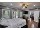 Bedroom featuring hardwood floors, natural light, a TV, and a four-poster bed at 547 Ellington Rd, Oxford, GA 30054