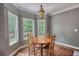 Bright dining area with a light fixture and large windows overlooking the backyard at 547 Ellington Rd, Oxford, GA 30054