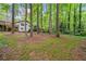 View of the home from the backyard showing a large grassy area and wooded surroundings at 1965 Stilesboro Nw Dr, Kennesaw, GA 30152