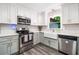 Well-lit kitchen with stainless steel appliances, farmhouse sink, and modern cabinetry at 1965 Stilesboro Nw Dr, Kennesaw, GA 30152