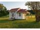 Charming outbuilding with a red metal roof, white siding, and a well-maintained lawn at 4076 Airline, Mcdonough, GA 30252