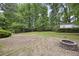 Expansive backyard showcasing a fire pit and a large grassy area, surrounded by lush trees and landscaping at 4468 Whitt Station Nw Run, Acworth, GA 30101