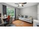 Cozy bedroom featuring a ceiling fan, hardwood floors, and a comfortable seating area by the bright window at 4468 Whitt Station Nw Run, Acworth, GA 30101