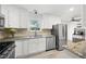 Bright kitchen features white cabinets, stainless steel appliances, and granite countertops at 4468 Whitt Station Nw Run, Acworth, GA 30101