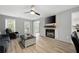 Open-concept living room features a decorative fireplace, windows, and modern fan at 4468 Whitt Station Nw Run, Acworth, GA 30101
