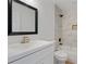 Modern bathroom features a tub with stylish tile surround, a white vanity, and a sleek black-framed mirror at 472 Rigby Ne St, Marietta, GA 30060