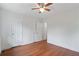 Well-lit bedroom with hardwood floors and a ceiling fan, complemented by two white doors and neutral walls at 472 Rigby Ne St, Marietta, GA 30060