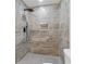 Modern shower featuring neutral stone tile, rain shower head, and tiled niche for storage at 472 Rigby Ne St, Marietta, GA 30060
