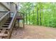 Wooden deck and staircase overlooking the spacious backyard with lush greenery and trees at 6416 Vicksburg Nw Ct, Acworth, GA 30101