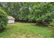 Spacious backyard featuring lush greenery, a partial fence, and a detached structure offering privacy at 1221 Oakfield Se Dr, Atlanta, GA 30316