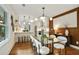 Inviting dining room featuring modern lighting, wood accent wall, and a glass dining table at 1221 Oakfield Se Dr, Atlanta, GA 30316