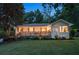 Inviting exterior showcasing manicured lawn, modern white brick, deck, and updated landscaping at 1221 Oakfield Se Dr, Atlanta, GA 30316