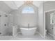 Bright bathroom features a soaking tub, glass-enclosed shower, arched window, and modern fixtures at 3341 Cranmore Chase, Marietta, GA 30066