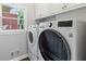 Bright laundry room featuring modern washer and dryer units with overhead cabinetry at 3341 Cranmore Chase, Marietta, GA 30066