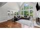 Open concept living room with hardwood floors, large windows, fireplace, and an adjacent modern kitchen at 3341 Cranmore Chase, Marietta, GA 30066