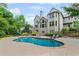 Beautiful backyard pool with stone surround and lounge chairs next to a gray two-story home at 3341 Cranmore Chase, Marietta, GA 30066