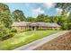 Classic brick home with a manicured front lawn and a long driveway on a wooded lot at 3845 Parian Nw Rdg, Atlanta, GA 30327