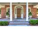 Classic brick home entrance with columns, decorative accents, and a wooden front door with stone porch at 3845 Parian Nw Rdg, Atlanta, GA 30327