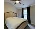 Bedroom features neutral colors, plush carpet, and ceiling fan; black curtains provide privacy at 589 Fox Creek Xing, Woodstock, GA 30188