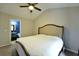 Cozy bedroom with neutral walls, plush bedding, and ceiling fan; bathroom visible through open door at 589 Fox Creek Xing, Woodstock, GA 30188