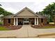 Community clubhouse featuring a brick facade, manicured landscaping and exterior lighting at 589 Fox Creek Xing, Woodstock, GA 30188