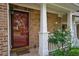 Welcoming front entrance featuring a stylish door, brickwork, and a charming rose bush at 589 Fox Creek Xing, Woodstock, GA 30188