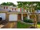 Inviting townhouse showcasing brick and siding, complete with an attached garage and well-maintained landscaping at 589 Fox Creek Xing, Woodstock, GA 30188