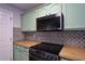 Well-equipped kitchen features stainless steel appliances, butcher block countertops, and a stylish backsplash at 589 Fox Creek Xing, Woodstock, GA 30188
